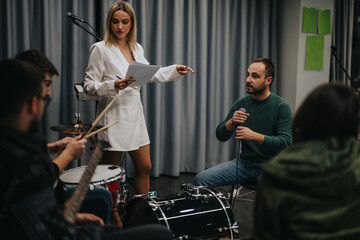 Musicians working together in a music studio, discussing strategy and practicing for an event.