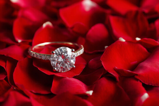 Sparkling diamond solitaire ring nestled inside vibrant red rose petals creating romantic mood