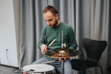 A dedicated musician practicing drums in a studio setting, showcasing skill and concentration. The image captures the essence of artistic expression and passion for musical performance.