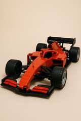 Fototapeta premium Red Formula Race Car Made from Toy Building Bricks on Beige Background 