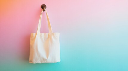 White tote bag hanging on pastel wall.