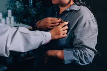Cropped image of male doctor's hand using stethoscope to examining heartbeat and symptom of patient...
