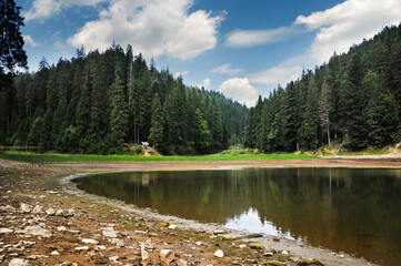 Carpathian Lake Synevyr surrounded by dense coniferous forest. seasonal changes in water levels