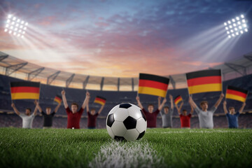 Soccer Ball on Green Grass With German Flag Fans Waving at Stadium Lights