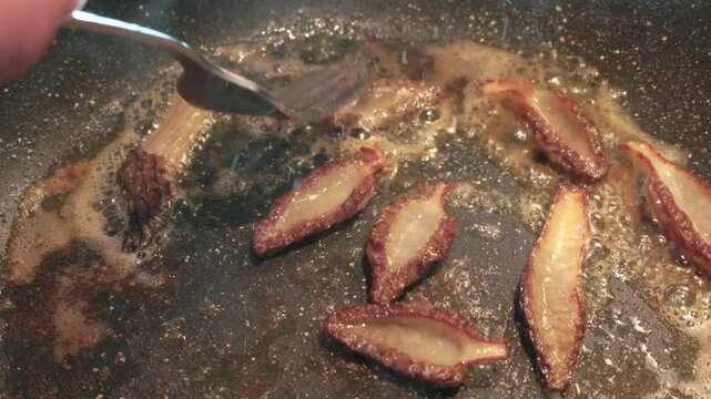 Frying morel mushrooms in a skillet using fresh butter and garlic salt