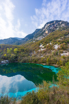 Cornino Lake reflecting clouds and mountains in Forgaria nel Friuli, Italy