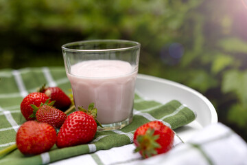 A close-up of a glass filled with strawberry yogurt, showcasing its creamy texture and fresh ingredients for food and beverage promotions