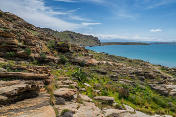 Rocky and lush landscape and Aegean Sea at the Paros Park on Paros island in Greece on a sunny day.