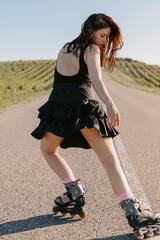 Sporty woman roller skating on sunny summer day