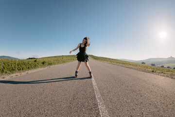 Fototapeta premium Woman roller skating on country road, leisure activity