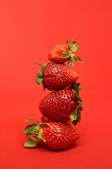 A lot of ripe tasty sweet strawberries lie on a red background. Bright summer background. Copyspace for your text. Template for poster, banner.  Summer colorful creative background.