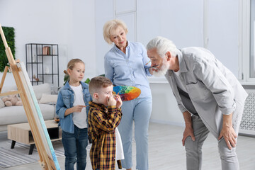 Grandparents and their grandkids painting together at home
