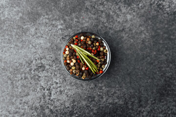 Colorful blend of spices arranged in a glass bowl on a textured surface