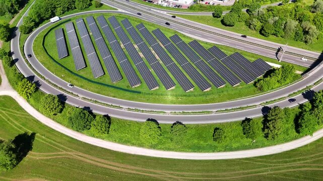 Aerial drone footage of circling over photovoltaic solar panels next to a highway