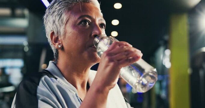 Mature, woman and drink water in gym for health, wellness and hydration after workout. Thirsty, breathing and bottle with h2o for nutrition, mineral and electrolytes for exercise at fitness center