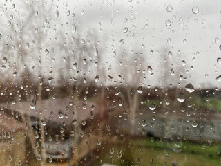 Rain drops on window, close-up. Rainy day. View outside blurred.
