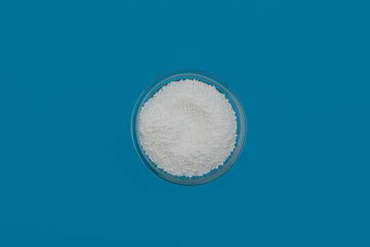 Sodium percarbonate powder or sodium carbonate peroxide in glass bowl, top view. It is abbreviated as SPC. Chemical substance used in eco-friendly bleaches with active oxygen