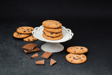 Chocolate chip cookies on a cake stand with chocolate bars