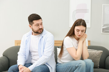 Resentful couple sitting on couch at home