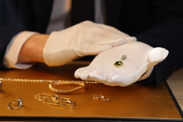 Appraiser working with luxury earring at table, closeup