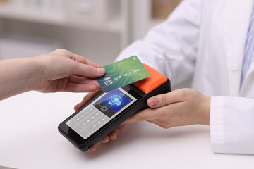 Payment terminal with NFC system. Client using credit card to pay for service in hospital, closeup