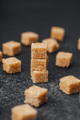 Sweet brown sugar cubes arranged on a dark surface for culinary use