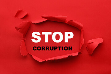 Words Stop Corruption, view through hole in red paper