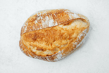 Freshly baked sourdough bread on a light surface in a kitchen setting