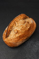 Freshly baked artisanal bread loaf resting on a dark surface