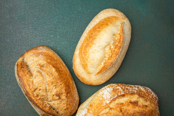 Freshly baked artisan bread on a green surface in a rustic setting