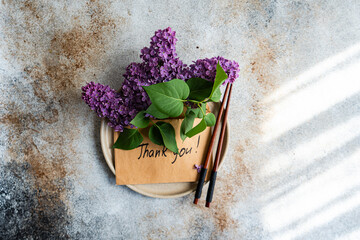 Purple flowers and thank you note on textured background