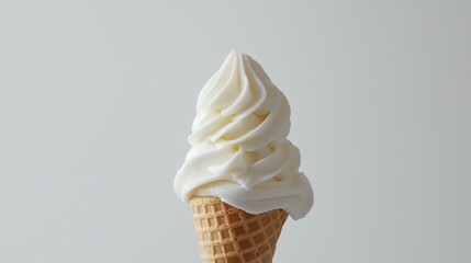Close-up of an ice cream cone. the cone is made of waffle and has a light brown color. the ice cream is a creamy white color and appears to be soft serve.