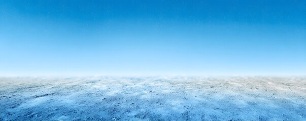 Fototapeta premium Vast barren landscape under a bright blue sky with minimal clouds during midday sunlight