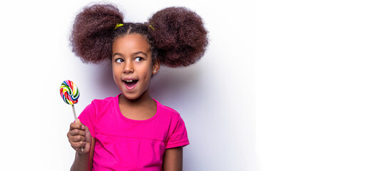 Funny african child with candy lollipop, happy little girl eating sugar lollipop