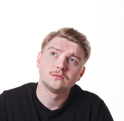 Obraz premium Lost in thoughts. Man with pensive thoughtful face looking away, thinking about something on white isolated studio background, portrait