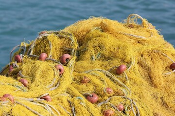 yellow fishing nets next to water, with red float bouys