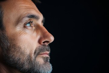 Obraz premium tight crop of a man in deep thought, intense eyes, black background 
