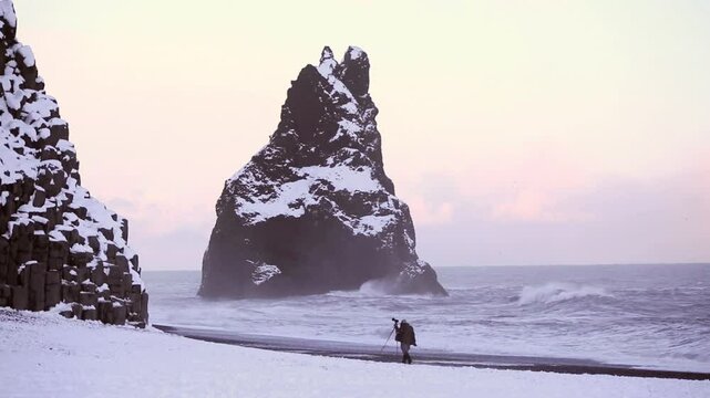 Photographer at the black sand beach in Vik, Iceland, evening light