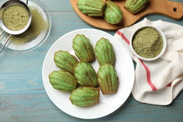 Tasty matcha madeleine cakes on light blue wooden table, flat lay
