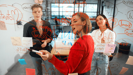 Creative start up team brainstorming marketing idea while cooperative caucasian businesswoman presents creative solution in front of glass board at business meeting. Working together. Immaculate.