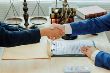 A client and lawyer shake hands to mark the completion of their legal agreement, symbolizing mutual...