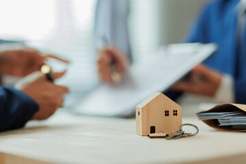 A real estate agent explains interest rates and home purchase contract details to a client, helping...