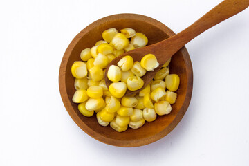 A wooden bowl with corn kernels, isolated on white background.