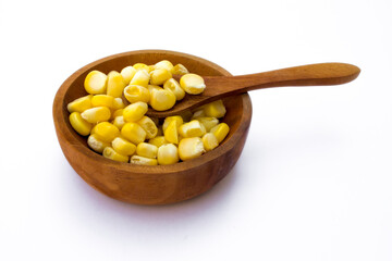 A wooden bowl with corn kernels, isolated on white background.