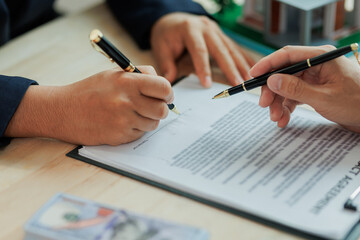 A real estate agent and client sign a home purchase agreement, formalizing the sale and confirming terms of the property transaction.