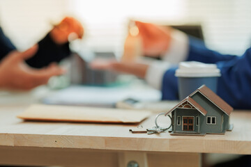 Real estate agent presenting a model home to a client as a housing option, highlighting guidance and property selection support.
