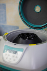 Fototapeta premium Modern laboratory centrifuge with lid open showing rotor and empty sample tubes prepared for scientific research and detailed analysis. Laboratory centrifuge on bench in laboratory.