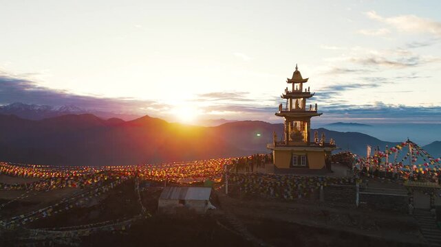 A tranquil sunset illuminating a Himalayan monastery with vibrant prayer flags fluttering in the foreground, framed by majestic mountains.