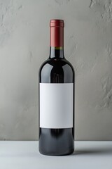 A bottle of red wine with a white label. The bottle is sitting on a table