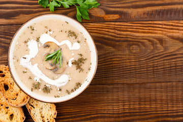 Delicious and healthy mushroom soup on wooden background